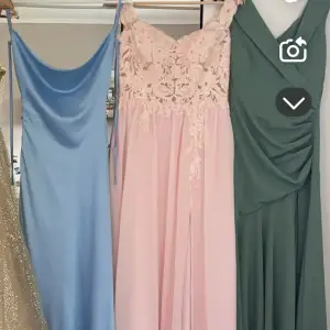 Elegant rosa långklänning med spetsdetaljer på överdelen och axelbandslös design. Perfekt för bal eller festliga tillfällen. Klänningen har en flytande kjol som ger en romantisk känsla. Även en slits som går upp gentemot benet.