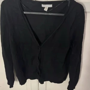 Svart kofta med knappar - Är lite nopprig och har några hårstrån på sig men det går bort