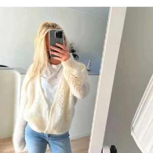 Vit stickad kofta - Säljer en mysig vit stickad kofta med lång ärm och knappar framtill. Perfekt för kyligare dagar och ger en avslappnad look. Passar bra till jeans eller klänning.