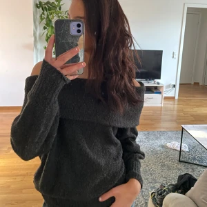 Mörkgrå offshoulder tröja - Säljer en mysig mörkgrå offshoulder tröja med långa ärmar. Perfekt för en avslappnad stil och kan enkelt matchas med jeans eller kjol. Tröjan har en bred krage som ger en trendig look. Passar bra för kyligare dagar. Pris kan diskuteras.