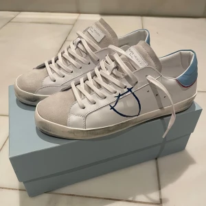 Philippe Model Junior Skor - Snygga vita sneakers med blåa och röda detaljer från Philippe Model. Storlek 37. Säljs pga felköp. Helt nya i kartong (oanvända). Skriv om funderingar. 