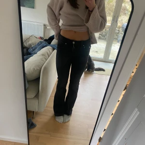 Svarta bootcut jeans - Snygga svarta bootcut jeans med låg midja med knappar på baksidan på fickan. Dom ör ifrån gina Tricot young i storlek 164 jag brukta ha storlek s dom passra mig 