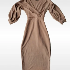 Beige midiklänning med knytband Bohoo - Elegant beige/natur/ljusrosa klänning med omlott-design och knytband i midjan från Bohoo. Den har trekvartsärmar och en figurnära passform som framhäver silhuetten. Perfekt för en stilren look. I fint skick och i stretchigt material.  