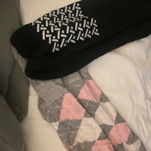 Två par strumpor med mönster - Säljer två par ridstrumpor. Det ena paret är svart. Det andra paret har ett klassiskt argyle-mönster i grått, rosa och beige, vilket ger en mysig och stilren look. 30kr styck eller båda för 50kr.