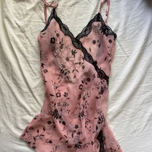 Spets linne - Gulligt men snyggt rosa spets linne med blommor på. Väldigt luftigt och perfekt på sommaren. Går att ha lös eller knyta vilket blir väldigt snyggt. 