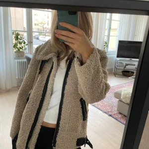 Cool teddyjacka - Säljer denna supercoola teddyjacka från zara. Kommer ej till användning men skulle passa perfekt i vinter och när det är lite kallare ute. Den är mycket varm och är i bra skick. Den är beige och i Teddy med svarta läder detaljer. 