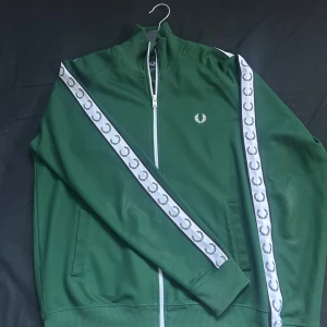 Fred perry track jacket - Grön vit freedperey trackacket, det är i nysick och väldigt försiktig använd. Nypris 1500kr