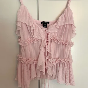 Rosa ljusrosa linne topp volanger söta detaljer volangtopp volanglinne populär trendig coquette slutsåld - Ett ljusrosa linne med volanger från New Yorker.  Aldrig använd, endast provad. Så nyskick!