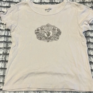 Beige tröja  - En beige tröja med tryck på, bra skick. Storlek s skulle jag säga (står ej på tröjan). Väldigt fin! 