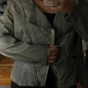 Skinnjacka  - Säljer denna super söta unika skinnjacka med så fina detaljer på! Kommer tyvärr inte till användning. Perfekt till hösten! Så fin grå färg 😍 står storlek 42 i men skulle säga att den är storlek M/S 