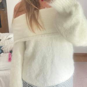 Säljer en supermysig vit offshoulder tröja från NA-KD. Den är fluffig och perfekt för kyliga dagar. Tröjan har långa ärmar och en lös passform som gör den extra bekväm. Perfekt för både vardag och fest! 💫