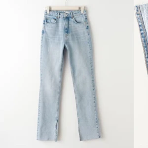 Ljusblå jeans med slits - Säljer ett par ljusblåa jeans med hög midja och slits vid anklarna. De har en straight passform. Storlek 36 från Ginatricot. Nyskick.