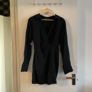Zara skjortklänning - Svart skjortklänning från Zara som tyvärr blivit lite för kort för mig. Litet hål i pga jag har fäst den med säkerhetsnål vid brösten.
