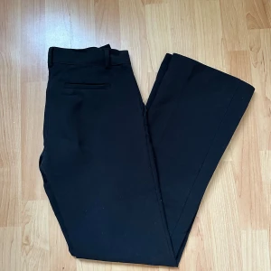 Lågmidjade kostymbyxor  - Svarta lågmidjade kostymbyxor från Nelly med fickor på sidorna. Storlek 32 men dom är stora i storleken☺️🌸