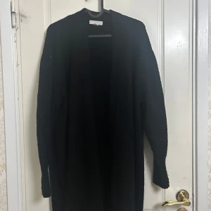 Svart cardigan  - Svart cardigan perfekt till hösten! Använts få gånger. Passar både dig som tar strl M och L. Materialet är stretchigt. 