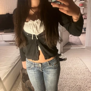 Svart kofta med knappar - Säljer en stilren svart kofta med knappar framtill. Passar till vilket linne eller blus som helst. Perfekt för lager-på-lager-stil.