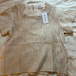 Snygg topp Wera - Snygg topp i champagnefärg från Wera med prislappen kvar! Storlek 36. Nypris 499kr