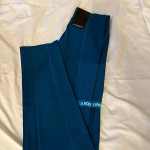 Blå leggings från J.Lindeberg - Snygga blå leggings från J.Lindeberg med ett stilrent mönster och logotypdetaljer. Perfekta för en aktiv livsstil. Tveka inte att höra av dig!💙