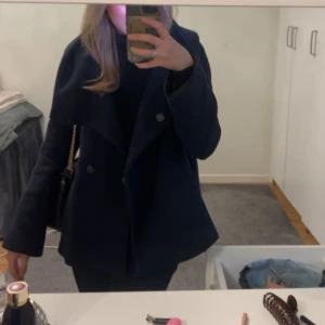 Marinblå kappa  - Snygg marinblå kappa och bred krage. Perfekt för kyligare dagar och ger en stilren look. Passar bra till både vardag och mer uppklädda tillfällen. Köp gärna via Plick