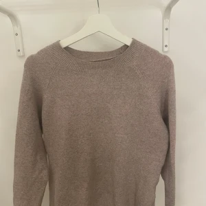 Ljusrosa tröja/beige  från Vero Moda - Mysig ljusrosa/beige tröja från Vero Moda i en mjuk och bekväm design. Perfekt för kyligare dagar med sin långärmade stil och rund halsringning. Enkelt att matcha med olika outfits.