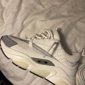 Dior b22 - Snygga vita sneakers från Dior som är helt nya. Använda endast 2 gånger. Perfekta för dig som vill ha en exklusiv look. Storleken på skorna är 42-42,5. Box och kvitto ingår. MVH Sebastian 😁