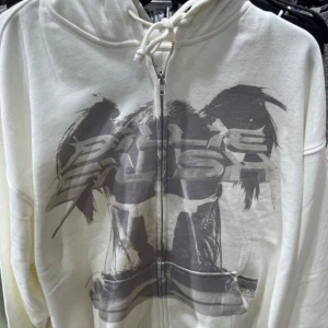 Vit hoodie med tryck med billie eilish (orginellt från H&M) - Säljer en vit hoodie med tryck från Billie Eilish. Hoodien har en dragkedja framtill och två fickor , inga defekter. Perfekt för fans av Billie Eilish eller annat! Pris kan diskuteras 