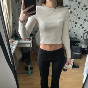 Beige ribbad croppad topp - En beige ribbad croppad topp med långa ärmar. Använts ett fåtal gånger, syns inte på tröjan.