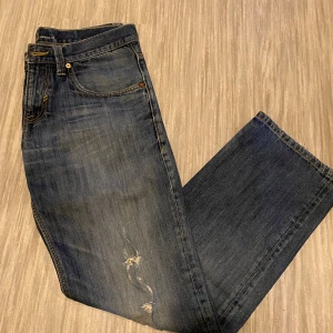 Blå jeans från Esprit - Snygga blå jeans från Esprit med en klassisk femficksdesign. De har en lätt slitning på framsidan som ger en cool, avslappnad look. Perfekta för en casual stil.