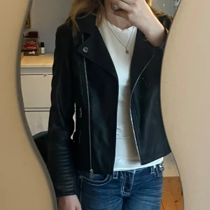 Svart skinnjacka från Art Class - Snygg svart skinnjacka från Art Class med dragkedja och knappar.  quiltade detaljer på ärmarna och två fickor med dragkedja.💗