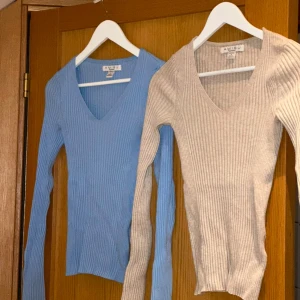 Ribbade tröjor från newyorker - Två ribbade tröjor från newyorker  i blått och beige. Båda har en v-ringad design och långa ärmar, perfekta för lager-på-lager under kyligare dagar.