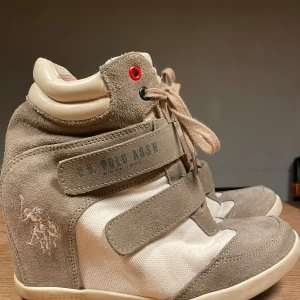 Isabelle Maurant liknande sneakers från U.S. Polo Assn. - Skitsnygga beige sneakers i mocka från U.S. Polo Assn. Säljer då de tyvärr är för små för mig! Storlek står inte men jag har storlek 38 och får in foten, men tårna kläms, så skulle säga att det är storlek 36 till 36 och en halv. 