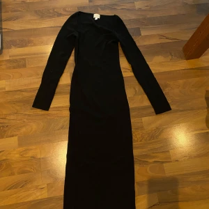 Svart långklänning - Elegant svart långklänning med långärmad design från H&M.