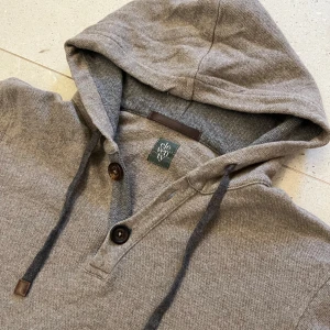 Eleventy kashmir-hoodie - Button up kashmir-hoodie från det Italienska designermärket Eleventy. | OBS: Sitter som XS | Skick: 9/10 | Kvalitativ - made in Italy i kashmirblandning (6% kashmir, 38% lanawool, 41% organic wool). Sjukt snygga detaljer såsom inristade knappar, äkta läder på snörena och längst nacken, svart sticknibgs längst hoodiens kanter och Eleventys klassiska vita sticknibg bredvid en av fickorna. Eleventys prisklasser på liknande tröjor ligger runt 10 tusen nypris, vårat förhandlingsbara pris —> 1099 kr 🤝