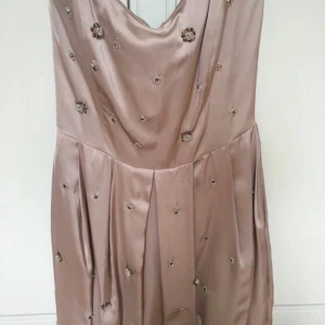 By Malene Birger, cocktailklänning nypris 3000kr - Cocktailklänning från by Malene Birger. Stl 40. Fickor på sidorna. Vissa pärlor har blivit lite lösa, men överlag bra skick. Liten i storleken. Nypris 3000kr.  Se mina övriga annonser, givetvis samfraktar jag. Jag postar alltid snabbt.