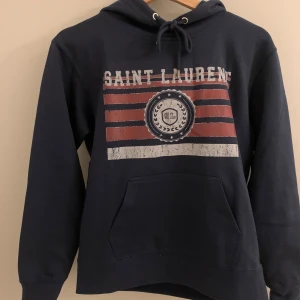 Saint Laurent hoodie - Snygg mörkblå hoodie från Saint Laurent då den är väldigt populär och eftertraktad. Hör gärna av er vid frågor.