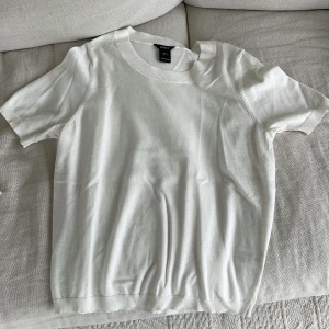 Vit kortärmad topp från Lindex - Säljer en fin vit topp från Lindex i storlek S. Den är kortärmad och har en rund halsringning. Perfekt för både vardag och fest. Materialet är mjukt och den är inte alls nopprig! Aldrig använd.