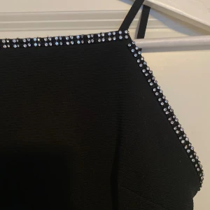 Svart body - Svart body med glitter detaljer från River Island. Använd en gång, så i väldigt gott skick. Storlek 34. Stretchig. 