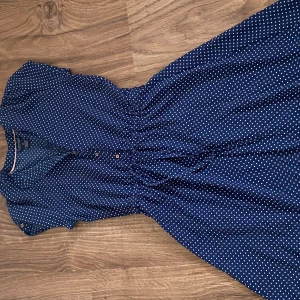 Mörkblå klänning  - Den går att knyta i midjan så man kan justera efter vad man själv önskar. 