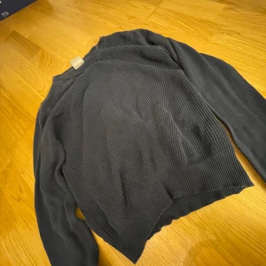 Svart stickad tröja från Vero Moda - Säljer en marinblå stickad tröja från Vero Moda i storlek S. Tröjan har en klassisk design med långa ärmar och ribbade detaljer vid halsen och nederkanten. Perfekt för kyliga dagar och kan enkelt matchas med olika outfits.