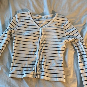 En fin randig blus🤍🖤 - Aldrig använd fint skick blus som man knäpper i mitten