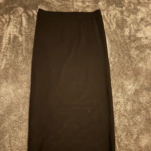 Kjol - Midi kjol, som två lager ett ”nätigt” och ett heltäckande under. Stretchigt material