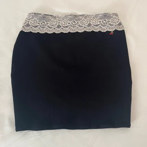 ”Cherry Lace” kjol - Svart kjol med stretch och resår i midjan, dekorerad med stretchig spets och en körsbärs-charm💗