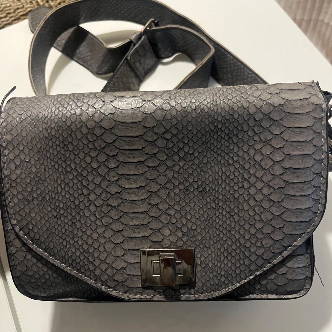 Grå axelväska med ormskinnsmönster