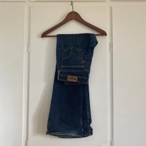 Lågmidjade levis jeans - Lågmidjade jeans i fint skick förutom lite slitningar på insidan av benet längst sömmen. Midjemått 76 cm och innerbenslängden 80 cm