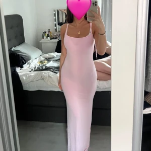 rosa klänning  - Säljer den trendiga ljusrosa långklänningen från Gina. Den har en figurnära passform som framhäver former. Klänningen är i storlek xs men väldigt stretchig. Helt oanvänd med prislapp kvar🩷