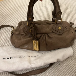 Marc Jacobs väska - Så snygg och eftertraktad väska från Marc Jacobs i en så fin brun färg med guld detaljer❣️inga defekter som syns på utsidan men den är lite smutsig på insidan men går att rengöra!