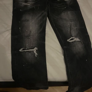 Svarta jeans från Supply & Demand - Coola svarta jeans från Supply & Demand med slitna detaljer och en avslappnad look. Perfekta för en trendig stil med en touch av edge. Tillverkade i Kina.