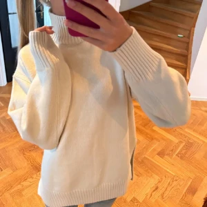 Vit stickad polotröja - Mysig vit stickad polotröja med långa ärmar och ribbade detaljer vid hals och ärmslut. Perfekt för kyliga dagar och ger en stilren look. Passar bra till jeans eller kjol för en avslappnad stil. Helt oanvänd❤️❤️❤️