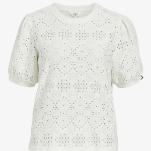 Vit blus med broderade detaljer - Säljer en söt vit blus från Object med broderade detaljer och korta puffärmar. Perfekt för en somrig look. Blusen har en rund hals och ett vackert mönster som ger en romantisk känsla.
