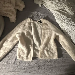 Beige stickad kofta - Mysig vit stickad kofta med långärmad design. Perfekt för kyliga dagar och att mysa i hemma. Enkel och stilren utan knappar eller dragkedja. Använd 5 gånger. Skulle säga att den passar XS och S. Köpt för 500 säljer för minst 300<3
